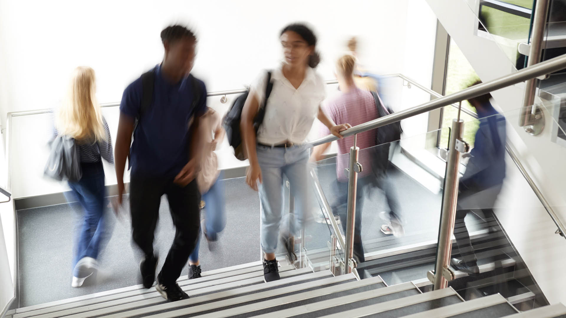 Blurred image of young people walking up stairs